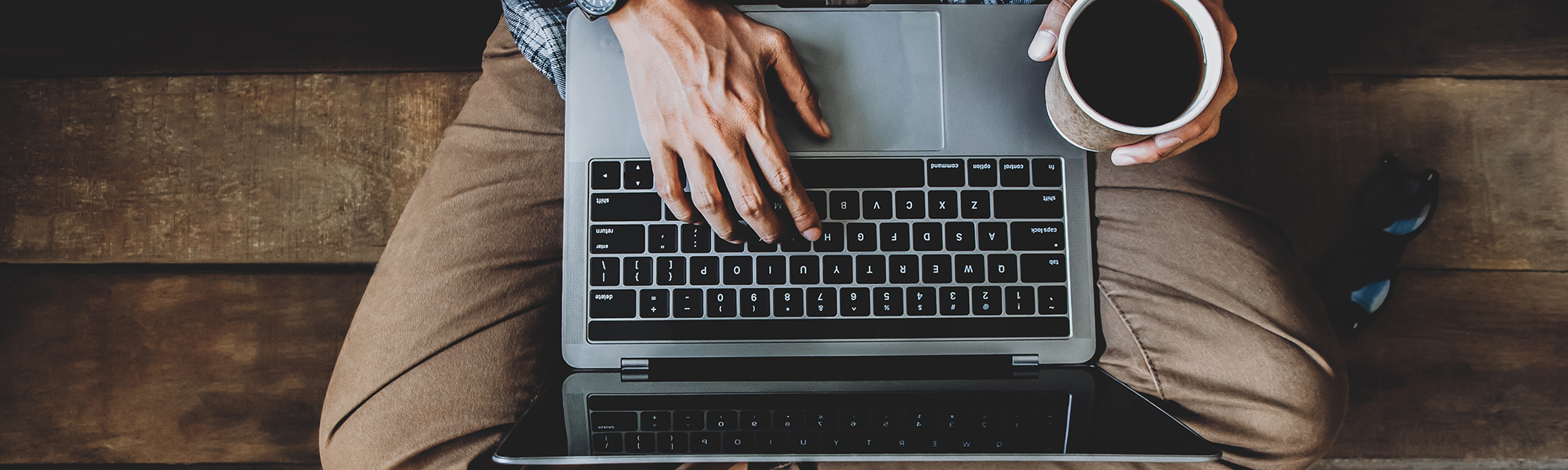 Man on his laptop with a coffee by his side